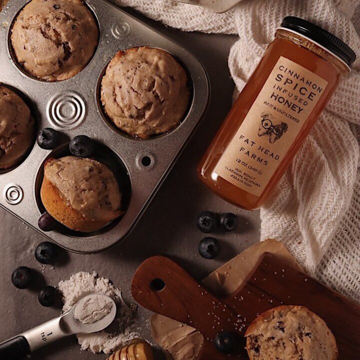 Fat Head Honey in a jar next to a pan of fresh muffins